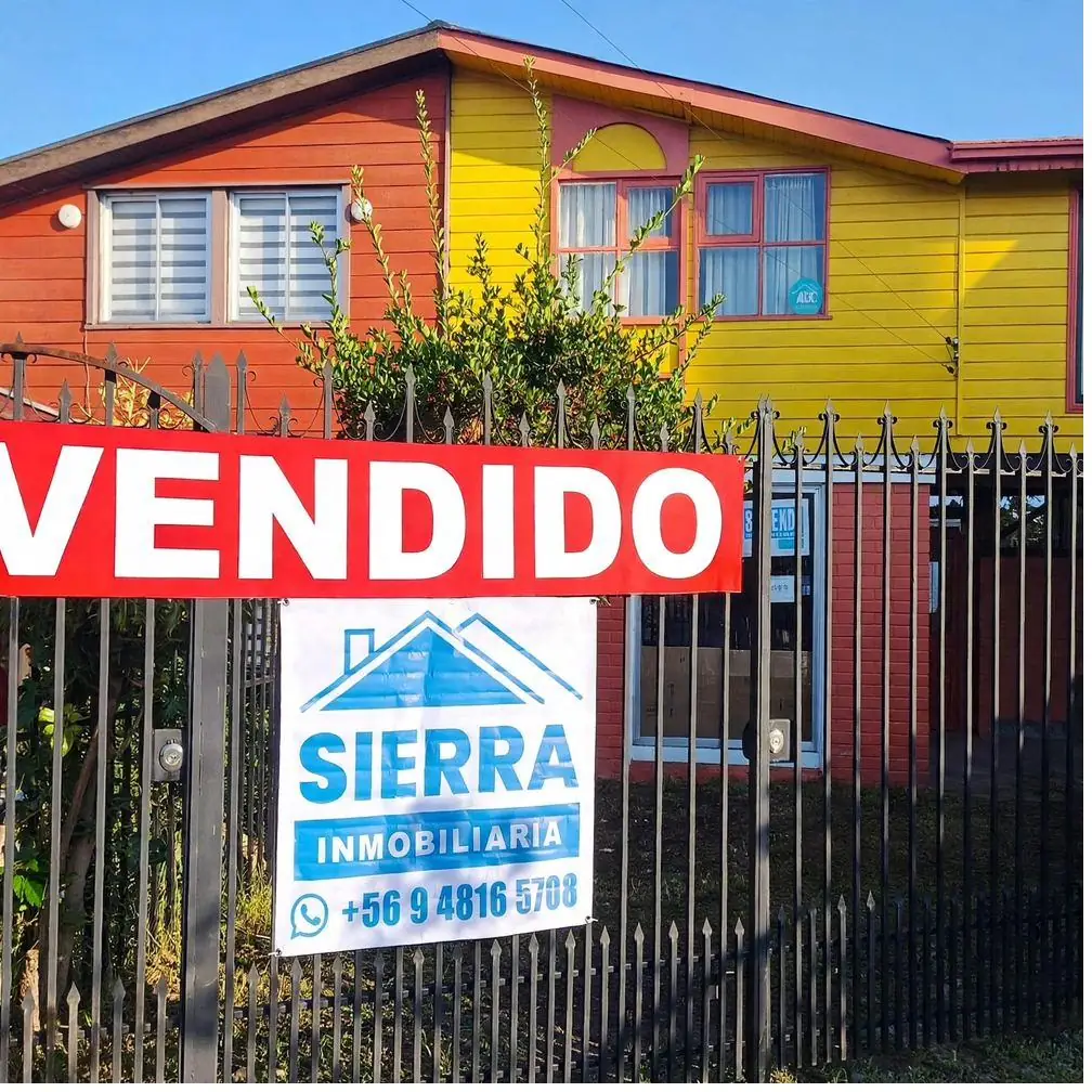 Casa con letrero de Sierra Inmobiliaria y cartel de vendido